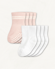 4-pack set of white and blush baby crew socks with silicone grips on an off-white background