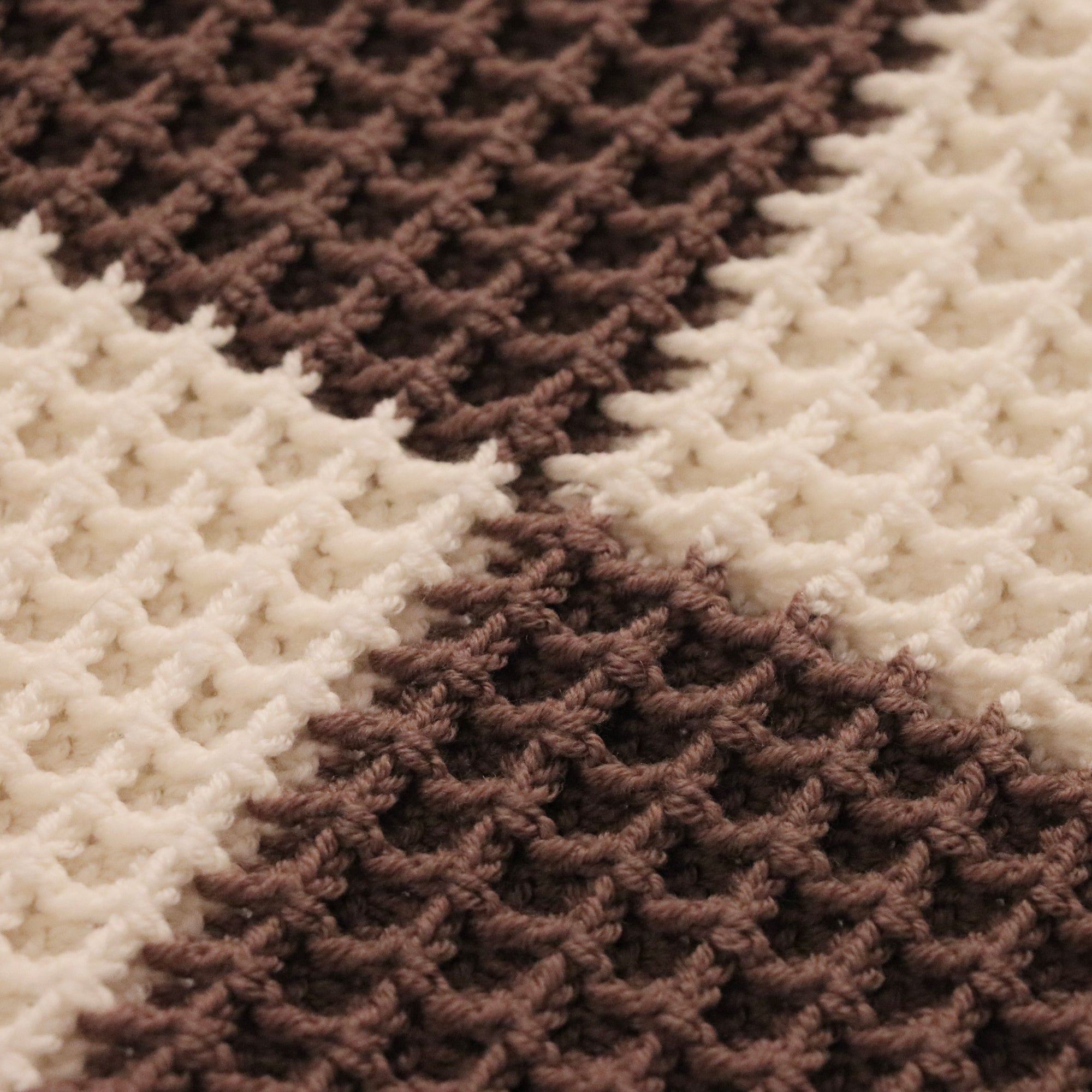 close-up of a merino wool checkered waffle knit baby lovey blanket in espresso brown and bone