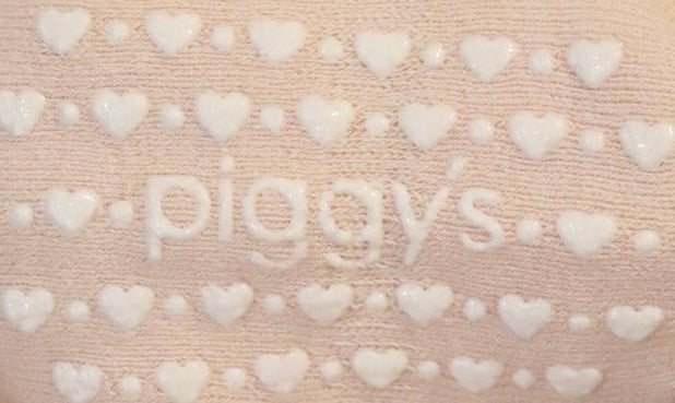 Silicone grippers of &#39;piggy&#39;s&#39; surrounded by hearts and dots on Piggy&#39;s baby crew socks in the color blush suede