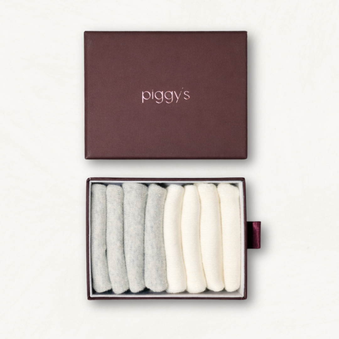 Open box displaying 2 pairs of heather grey and 2 pairs of white toddler socks with 'piggy's' branding on a white background.