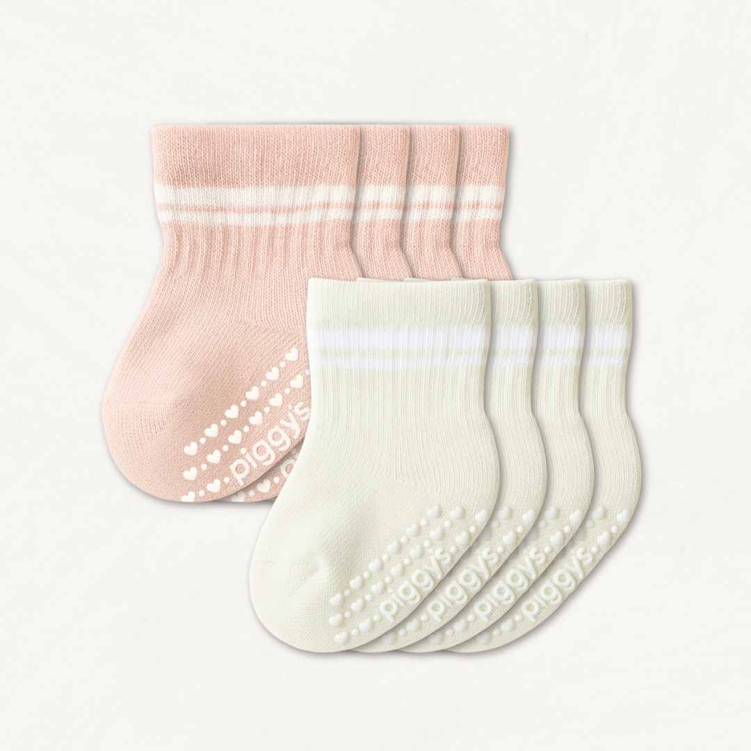 Set of off-white and blush pink baby crew socks with white stripes and silicone grips on an off-white background