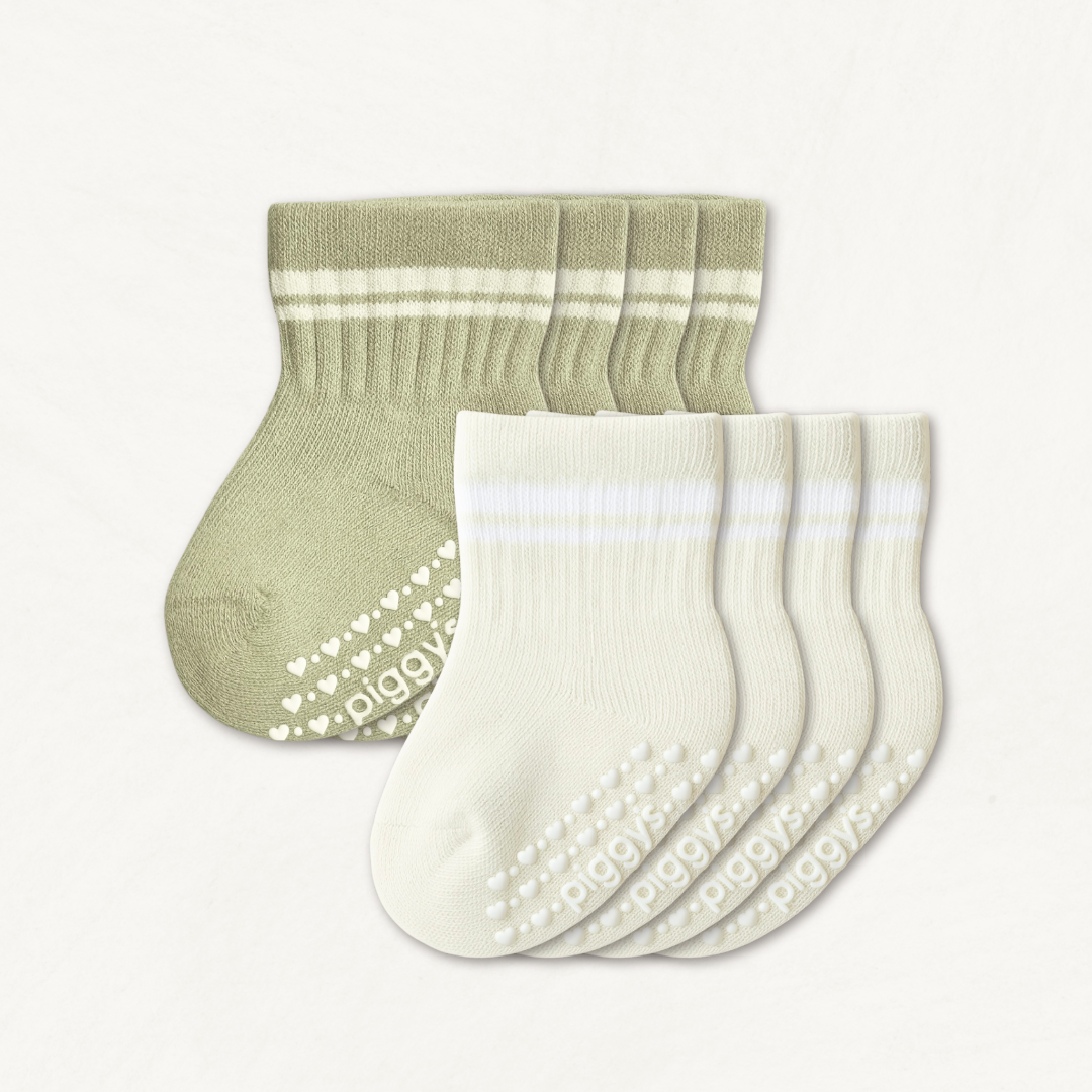 Set of off-white and light sage baby crew socks with white stripes and silicone grips on an off-white background